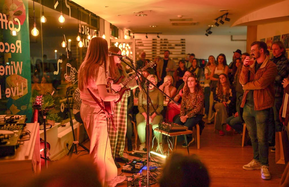 A singer performing to a packed room at 12 Bar, Exeter