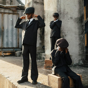 Ezra Collective Here Because of Hope album cover artwork showing three children in suits on a street	